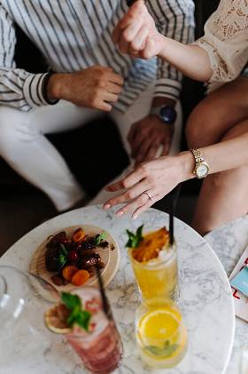Des amis attablés autour de boissons et d'assiettes à partager